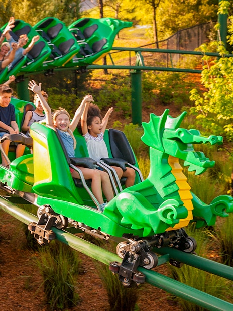Visitors enjoying a dragon-themed roller coaster at LEGOLAND Windsor Resort.