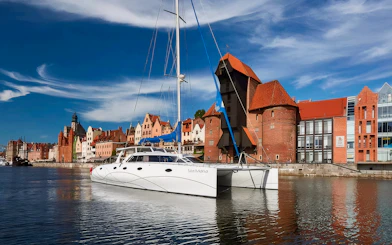 Catamaran docked in Sopot with historic waterfront buildings in the background.