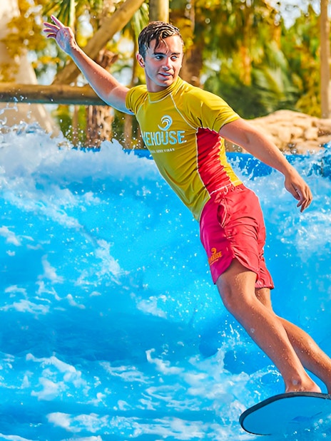 Surfer riding wave at Aquaventure Waterpark, Dubai.