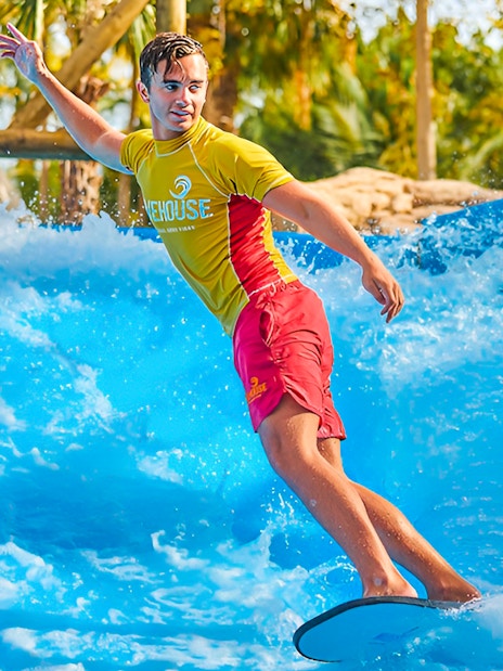 Surfer riding wave at Aquaventure Waterpark, Dubai.