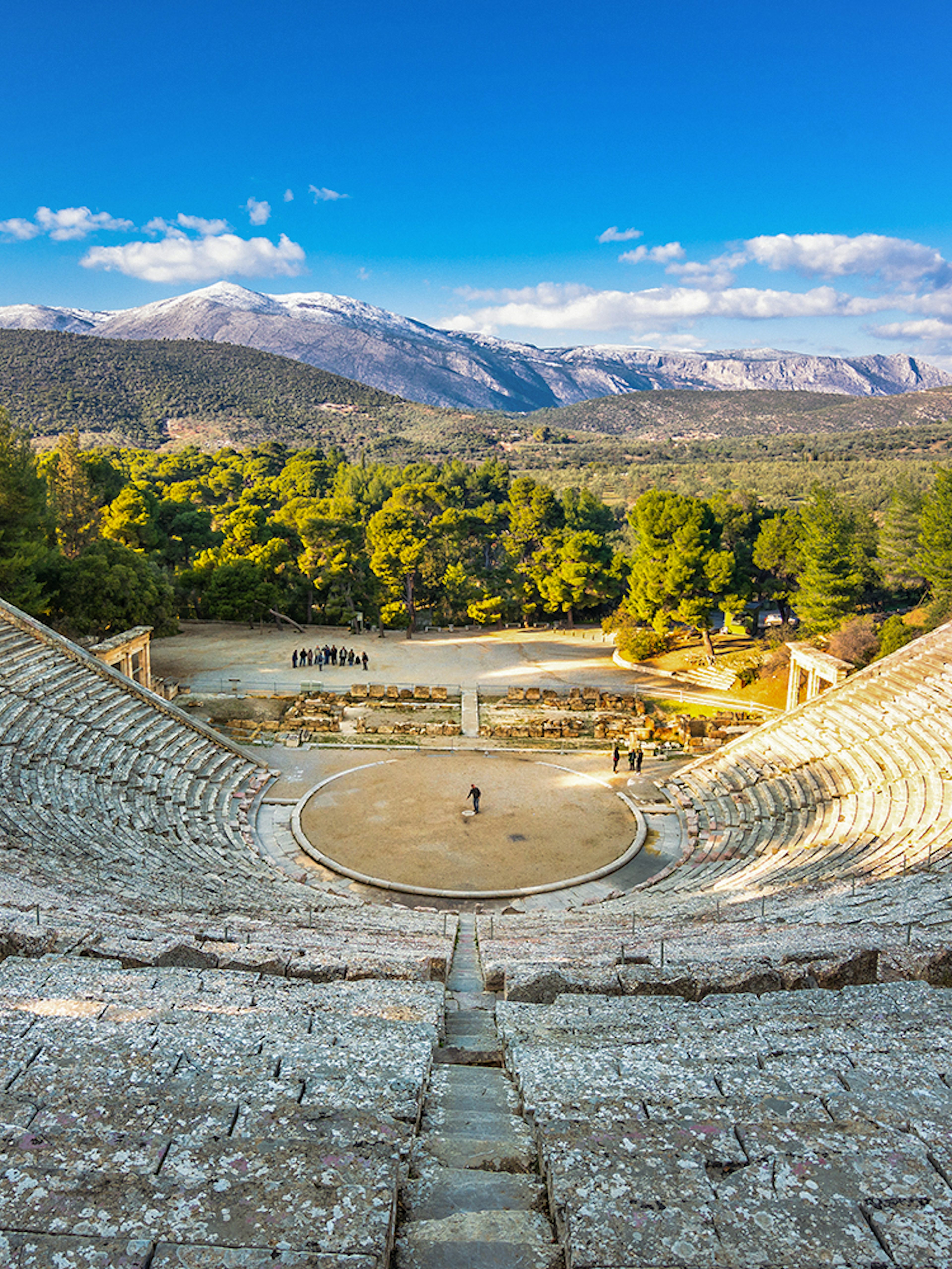 Epidaurus Ancient Theatre with scenic mountain backdrop in Greece.