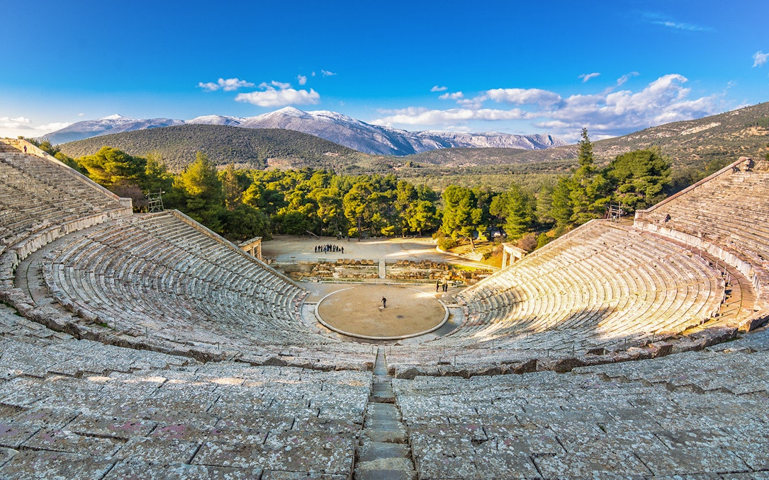 Epidaurus Ancient Theatre with scenic mountain backdrop in Greece.