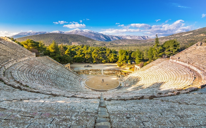 Epidaurus Ancient Theatre with scenic mountain backdrop in Greece.
