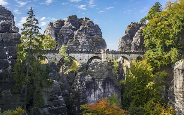 Bastei Bridge in Saxon Switzerland surrounded by rock formations and autumn trees.