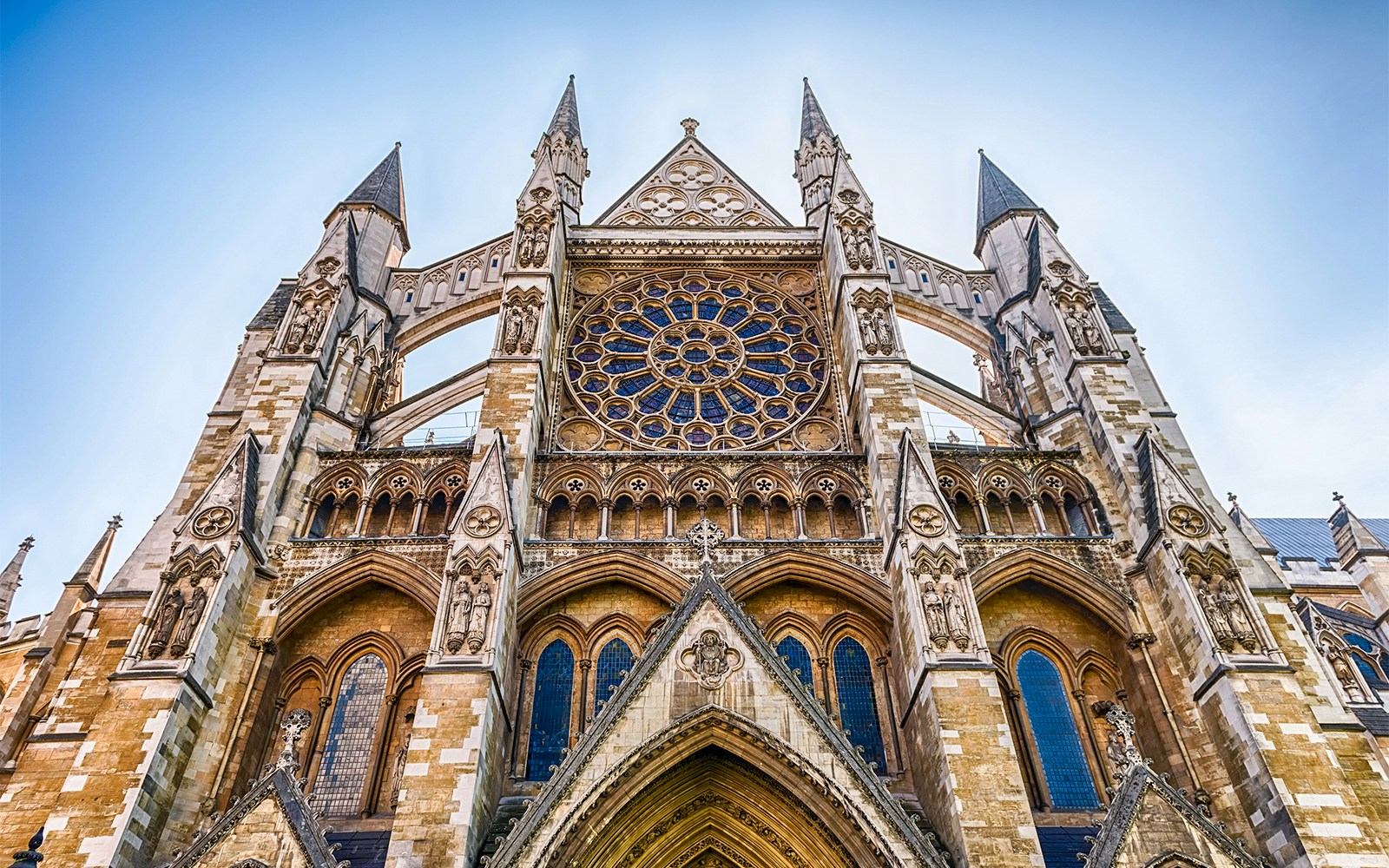 Westminster Abbey facade with intricate Gothic architecture and rose window in London.