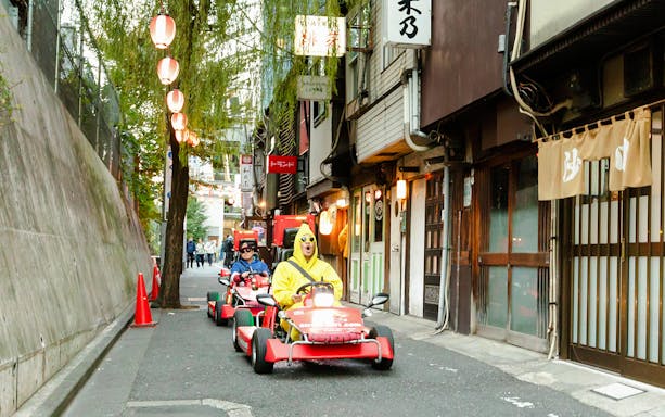 Tourists in go karts driving through Shibuya streets during Tokyo go karting experience.