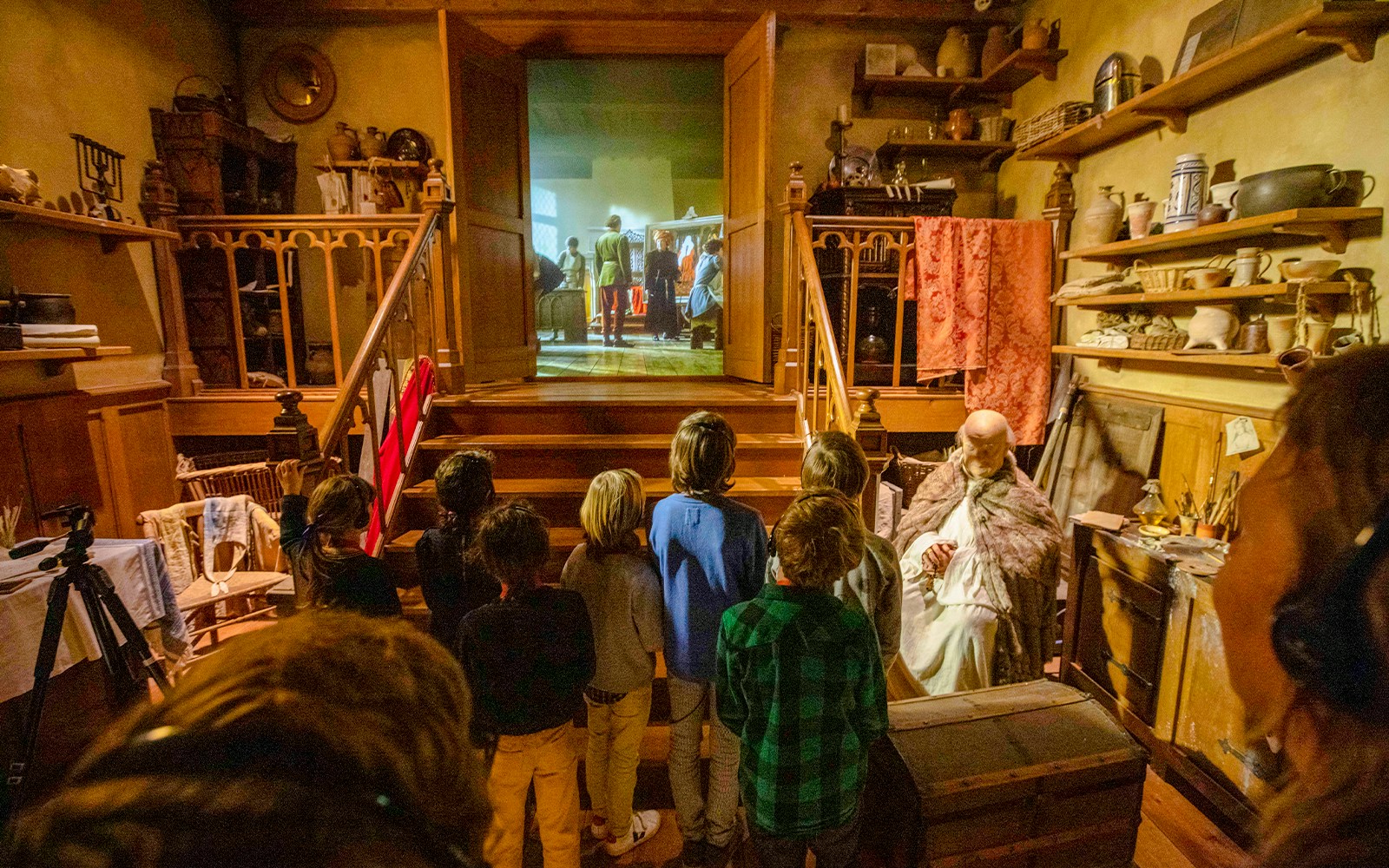 Guests watching a historical reenactment at Historium Bruges, featuring medieval decor and artifacts.