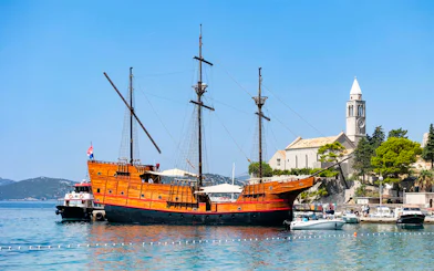 Karaka ship docked near a historic church on the Elaphite Islands cruise.