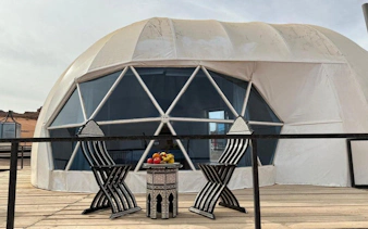 Geodesic dome tent with chairs and table at Wadi Rum campsite, Jordan.
