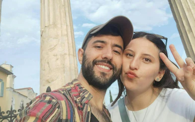 Couple posing in front of ancient columns in Plaka, Athens during a self-guided city exploration game.