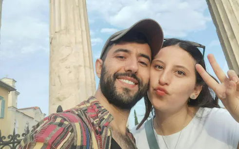 Couple posing in front of ancient columns in Plaka, Athens during a self-guided city exploration game.