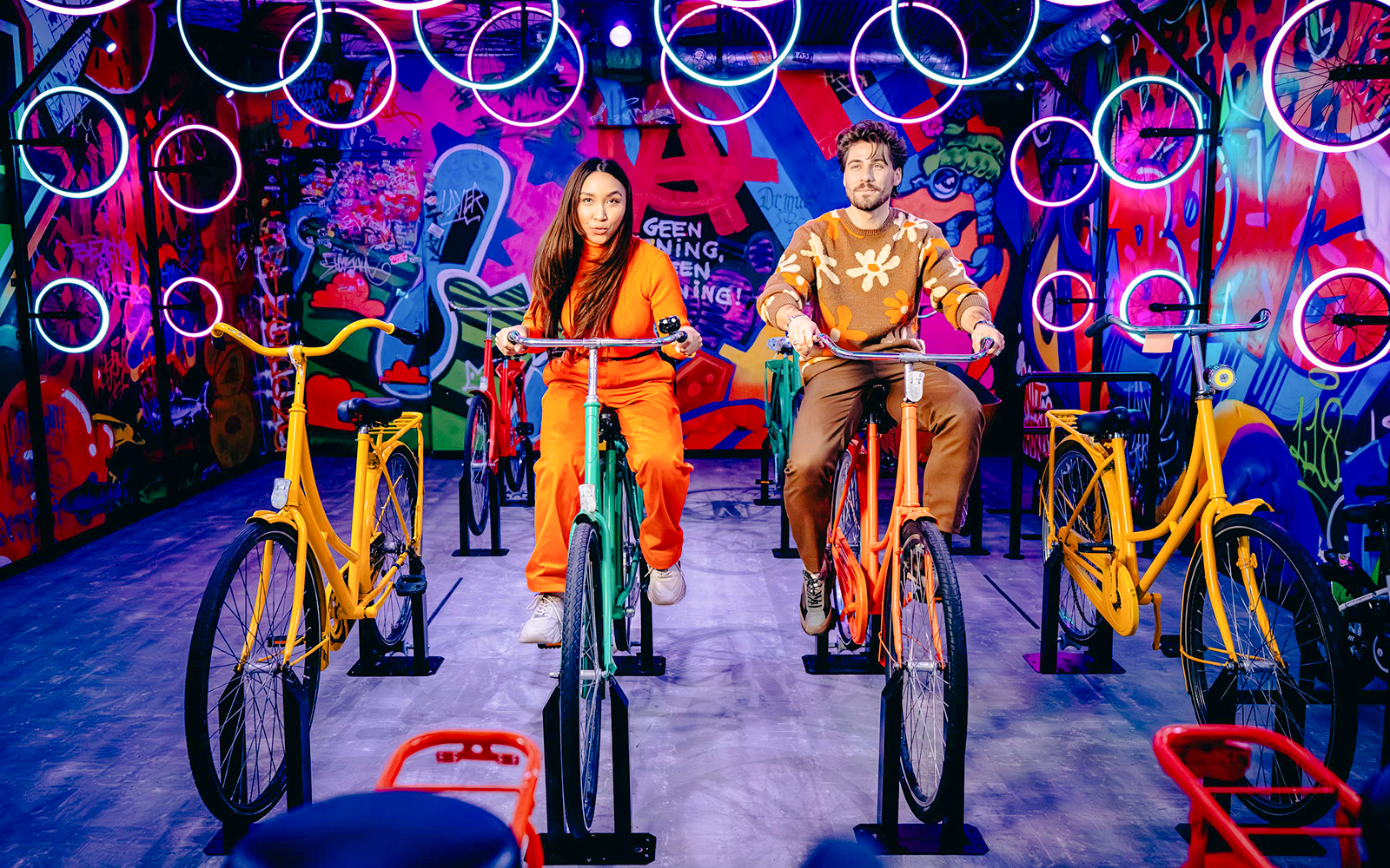 Guests cycling indoors with vibrant graffiti in Highlights of Holland experience.