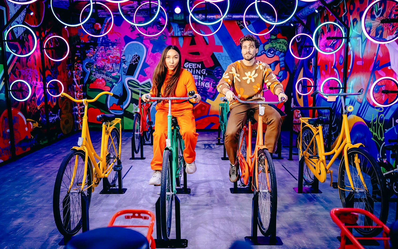 Guests cycling indoors with vibrant graffiti in Highlights of Holland experience.