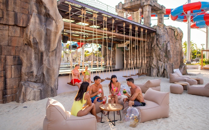 Group enjoying drinks at Andamanda Phuket Water Park lounge area.