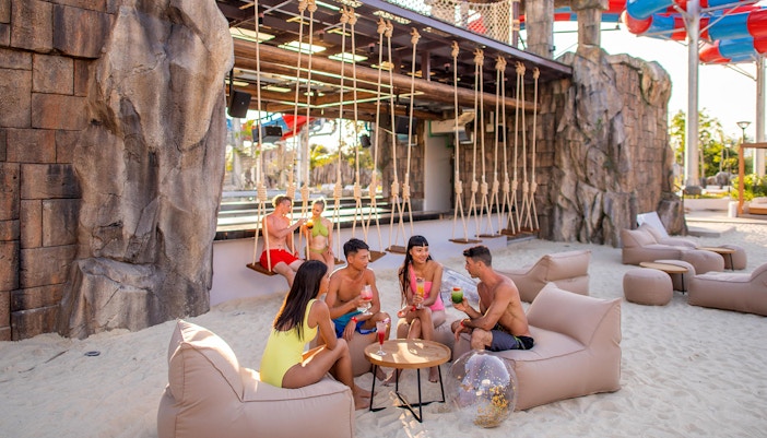 Pessoas tomando um drinque no bar de areia do Andamanda Phuket