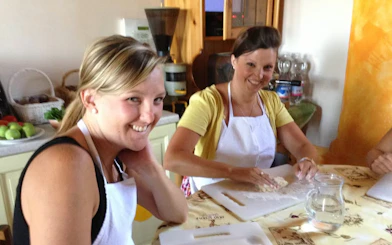 Women participating in a cooking class during a Tuscany day trip.