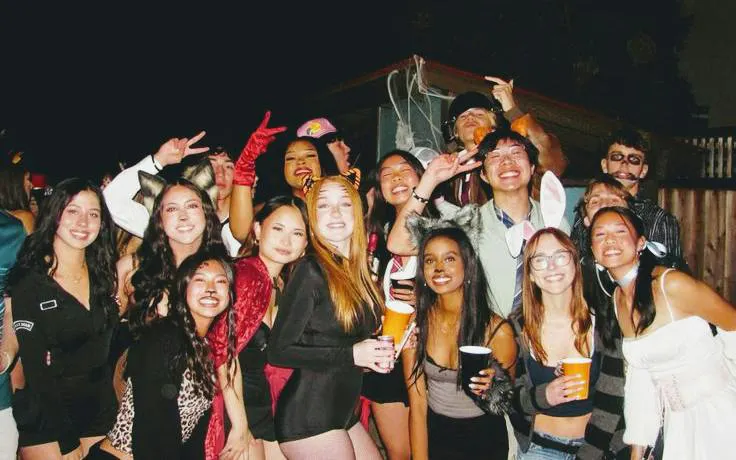 Group of people in costumes enjoying a Halloween party in Barcelona nightclub.