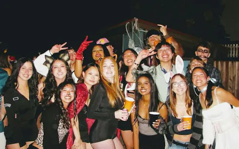 Group of people in costumes enjoying a Halloween party in Barcelona nightclub.