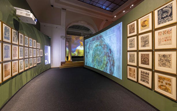 Exhibition hall with framed Mucha artworks and digital projections at iMucha Exhibition.
