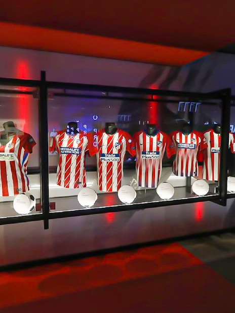 Atlético Madrid jerseys and soccer balls on display at Territorio Atleti, Cívitas Metropolitano tour.