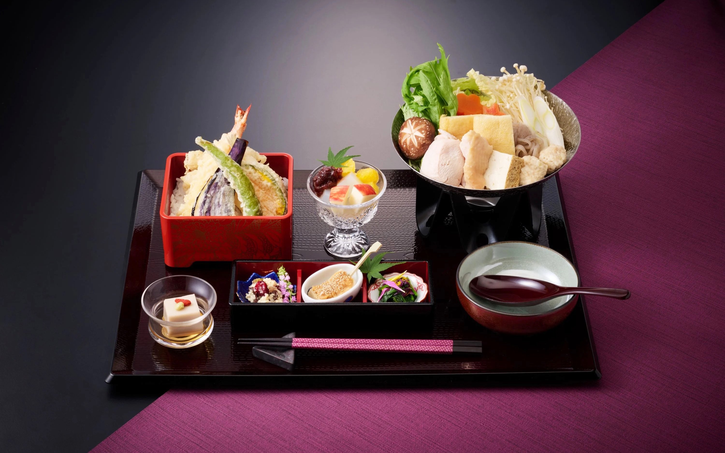 Traditional Japanese meal with tempura, hot pot, and assorted side dishes.