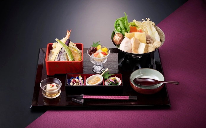 Traditional Japanese meal with tempura, hot pot, and assorted side dishes.