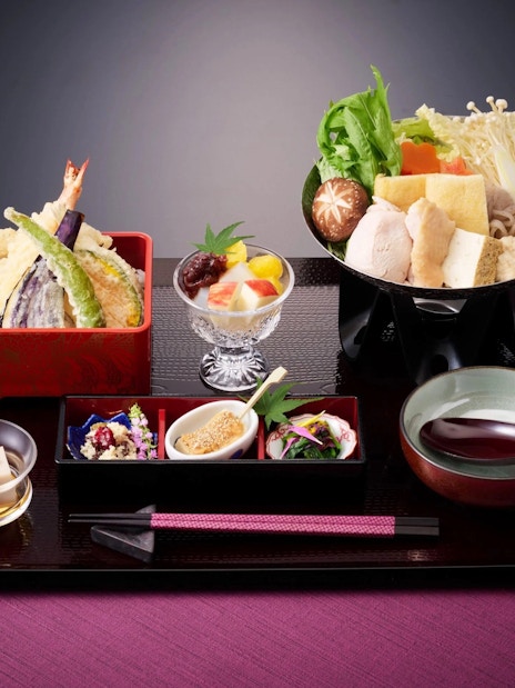 Traditional Japanese meal with tempura, hot pot, and assorted side dishes.