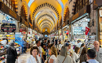 Crowded Spice Bazaar in Istanbul with tourists exploring food stalls.