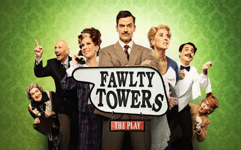 Cast of Fawlty Towers play posing with a sign against a green background.
