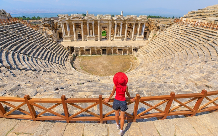Woman tourist overlooking the ancient theater of Hierapolis in Turkey.