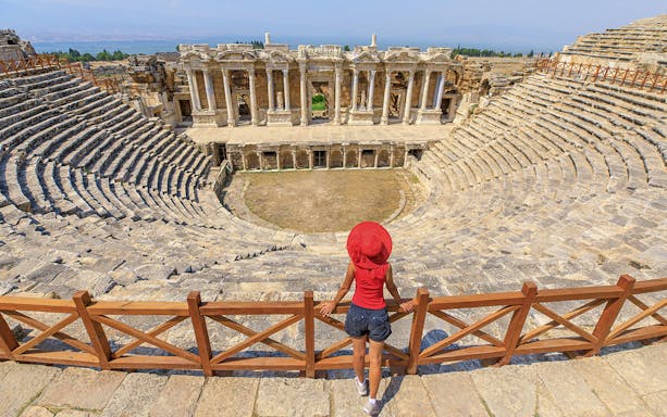 Woman tourist overlooking the ancient theater of Hierapolis in Turkey.