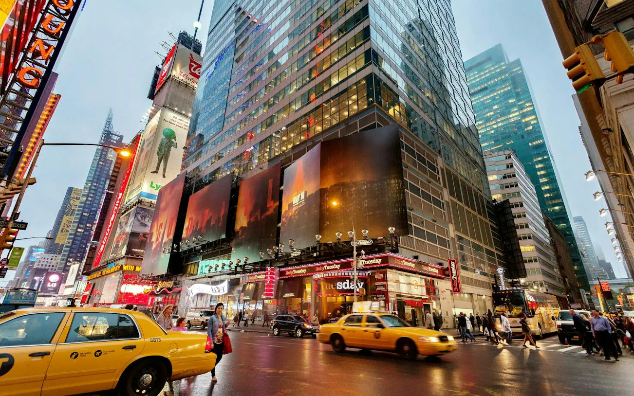 Times Square street view with yellow taxis and illuminated billboards, New York City.