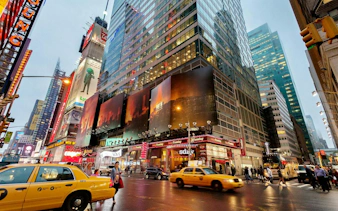 Times Square street view with yellow taxis and illuminated billboards, New York City.