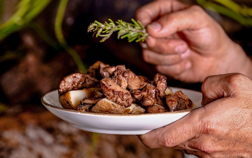 Traditional Maltese dish with roasted meat and herbs at a folklore dinner show.