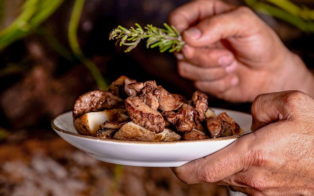 Traditional Maltese dish with roasted meat and herbs at a folklore dinner show.
