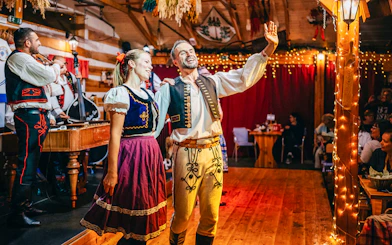 Performers in traditional attire during Folklore Dinner Show in Prague.