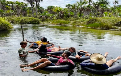 Tubing adventure in Cardosa river, Barreirinhas with group enjoying lush surroundings.