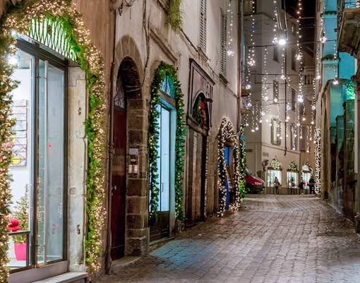 Barcelona streets at night with illuminated buildings and bustling pedestrians.
