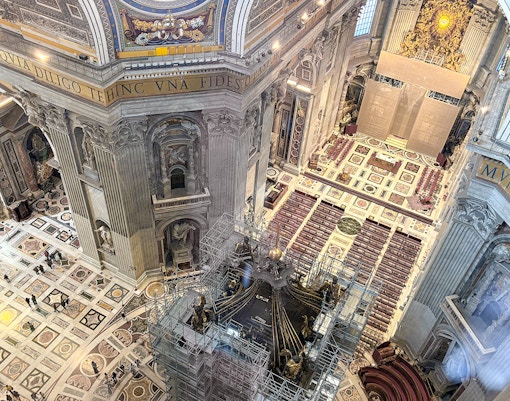 View of St. Peter's Basilica interior from the dome, showcasing ornate architecture and Vatican City landmarks.