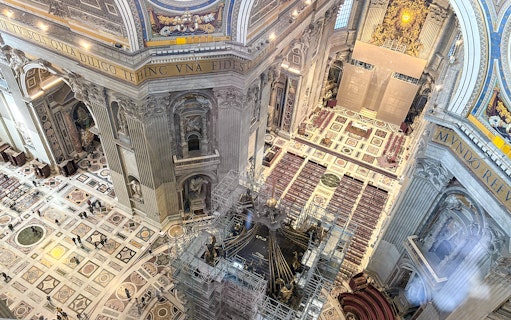 View of St. Peter's Basilica interior from the dome, showcasing ornate architecture and altar.