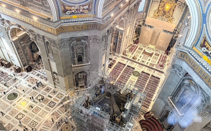 View of St. Peter's Basilica interior from the dome, showcasing ornate architecture and altar.