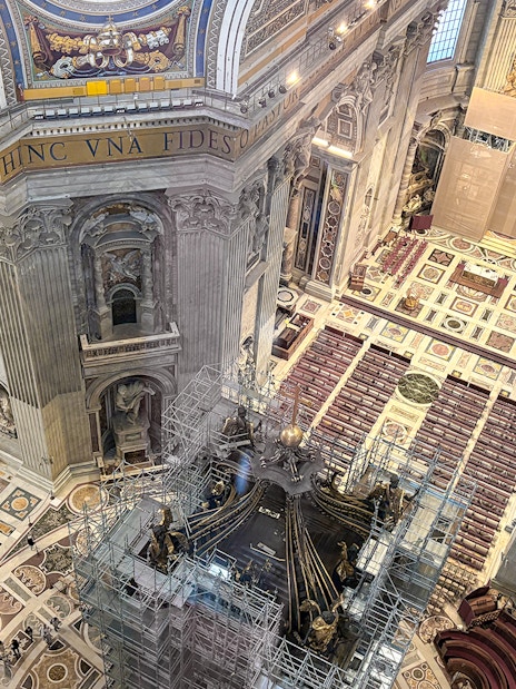 View of St. Peter's Basilica interior from the dome, showcasing ornate architecture and altar.