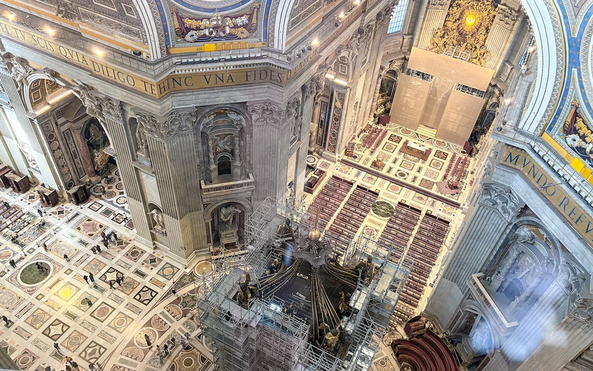 View of St. Peter's Basilica interior from the dome, showcasing ornate architecture and altar.