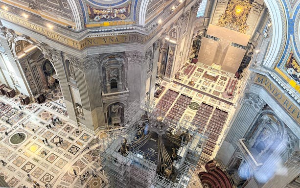 View of St. Peter's Basilica interior from the dome, showcasing ornate architecture and altar.
