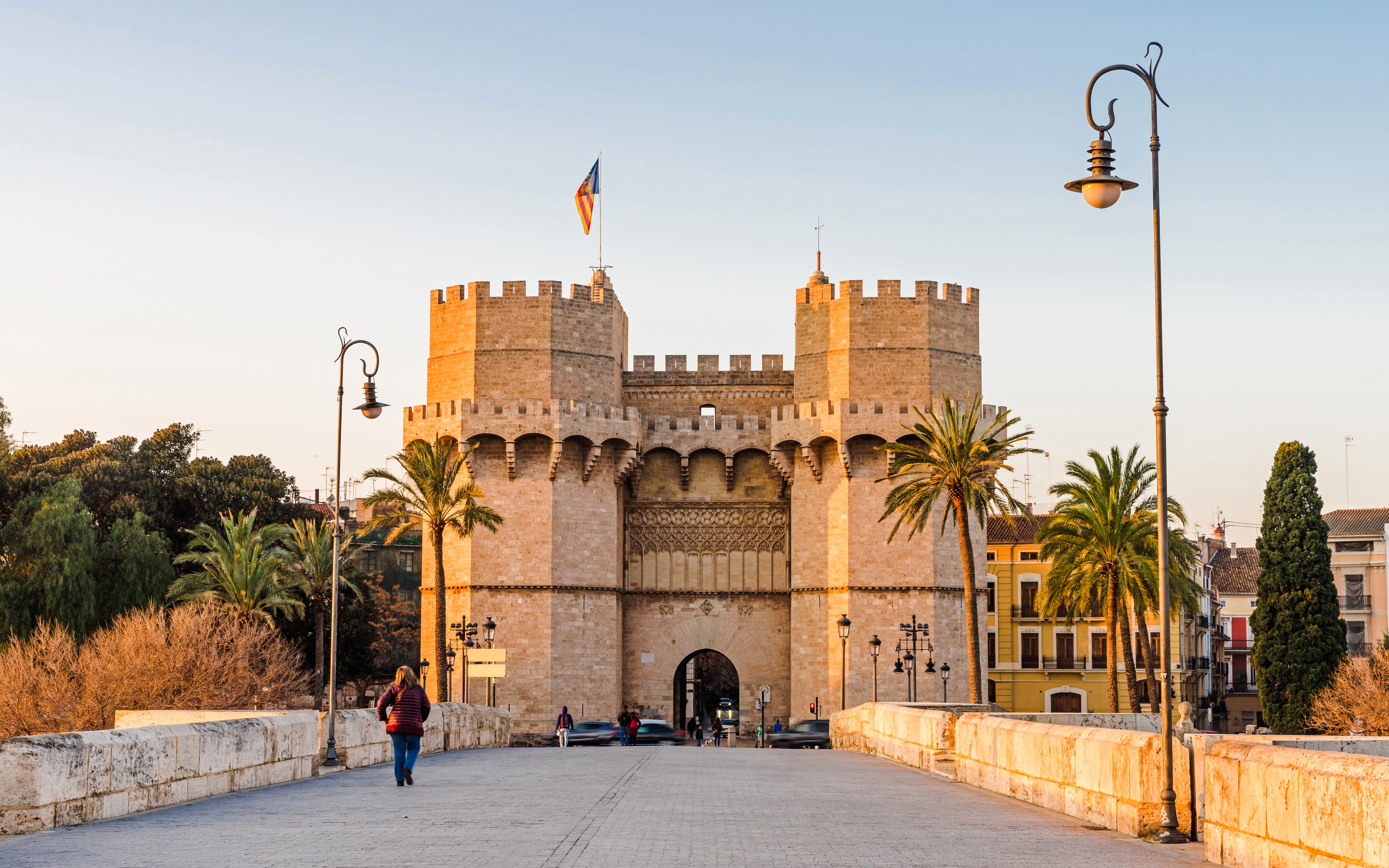 Torres de Serranos gate in Valencia with people walking on the bridge.