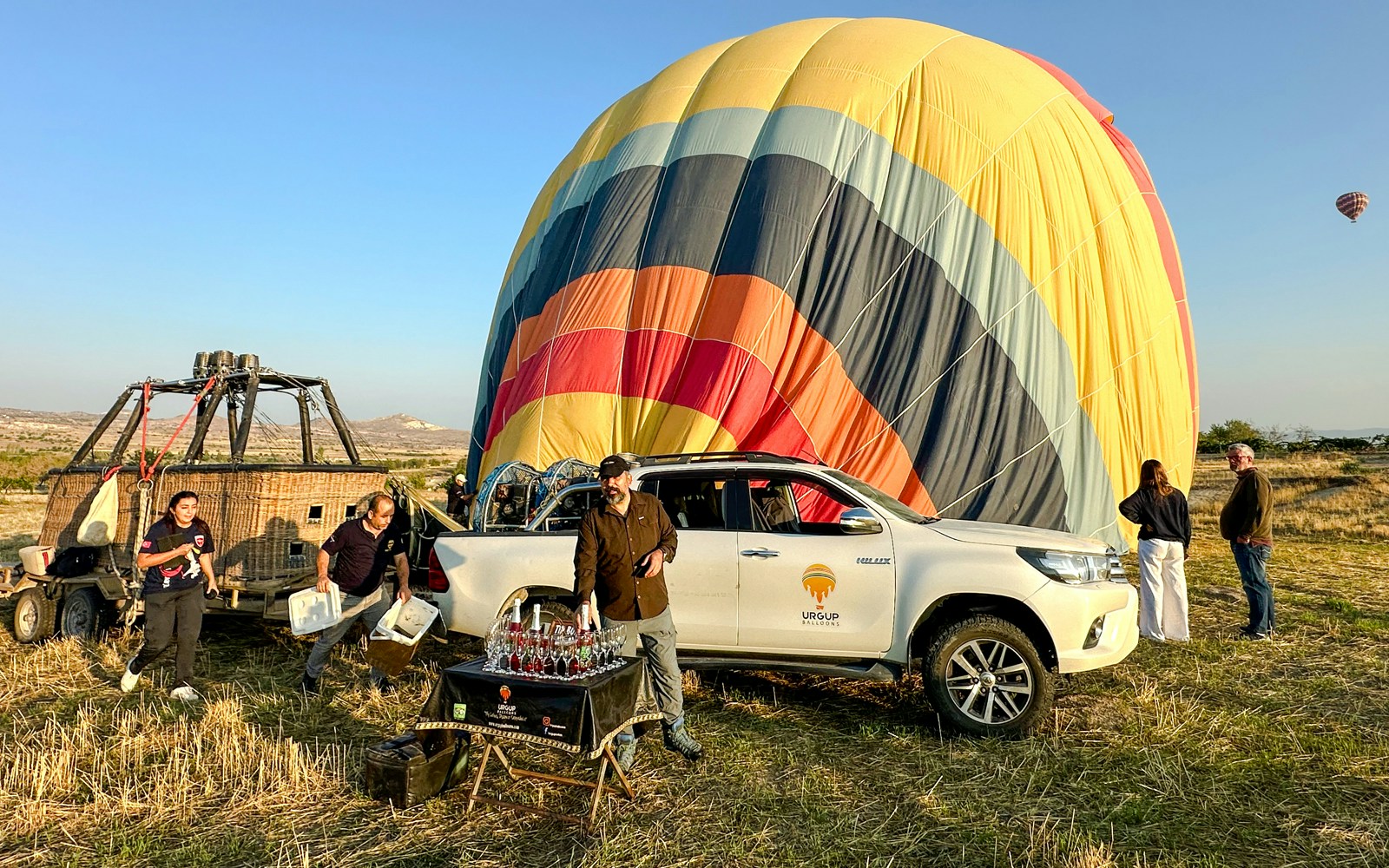 Hot air balloon preparation in Cappadocia with crew and guests, sunrise tour setup.