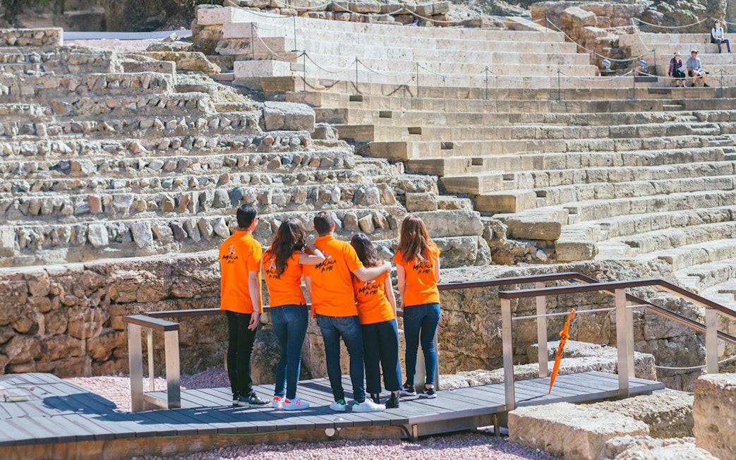 Visitors exploring the Roman Theater in Málaga during a guided tour.