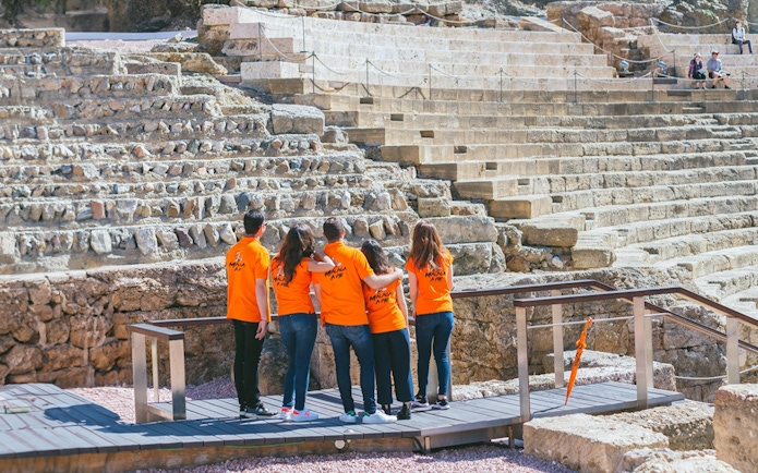 Visitors exploring the Roman Theater in Málaga during a guided tour.