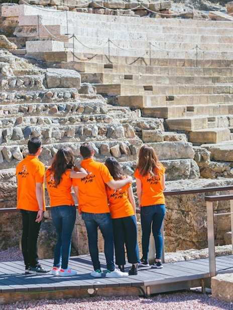 Visitors exploring the Roman Theater in Málaga during a guided tour.