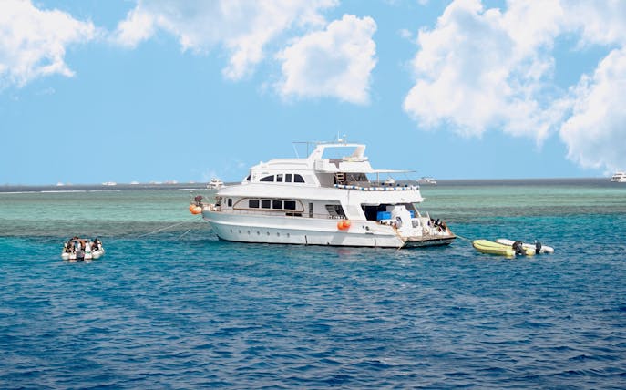 Diving boat anchored near coral reef island in Hurghada, Egypt.